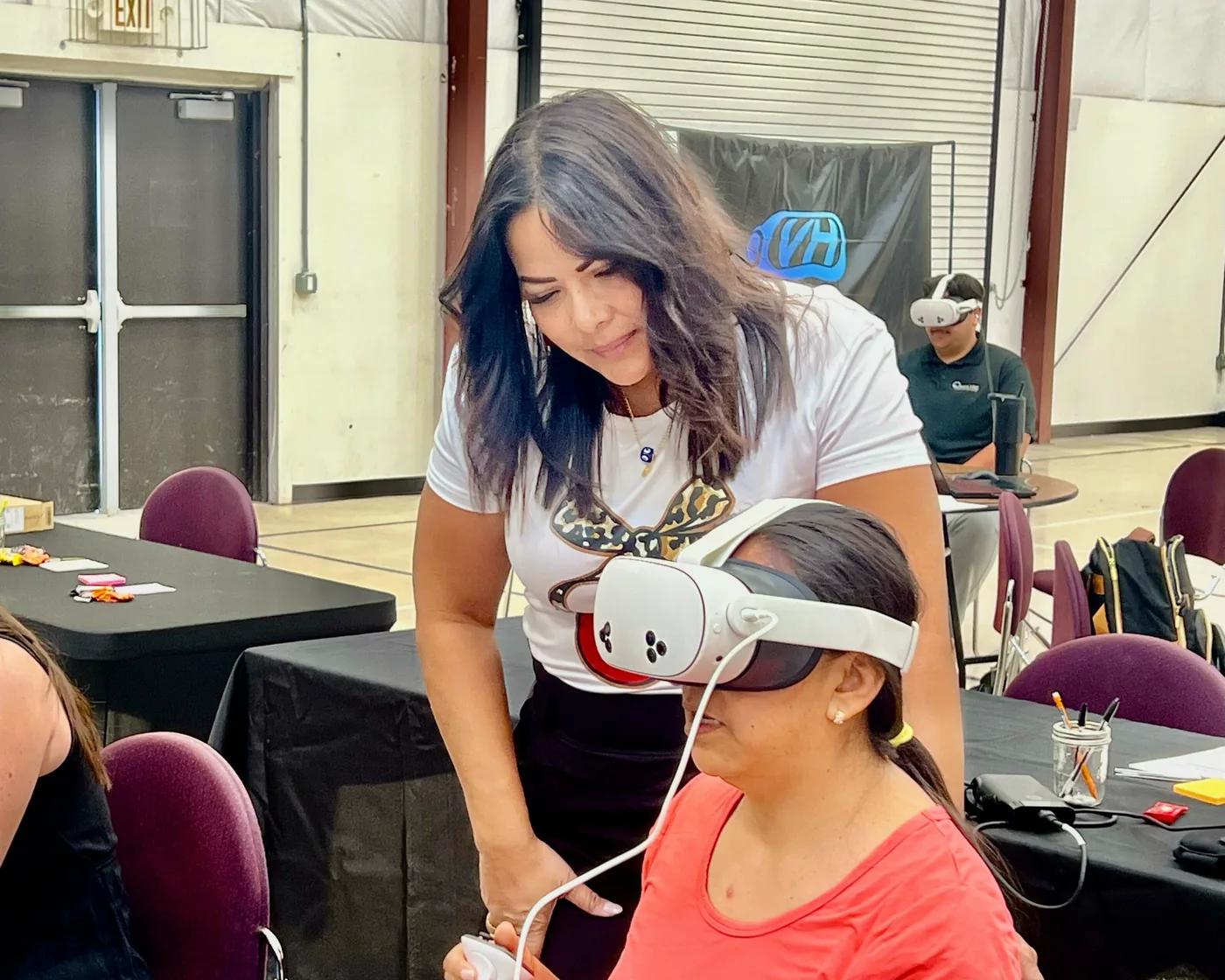 A VHCS teacher being helped into a headset during onboarding training.